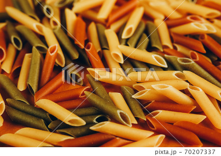 Frame made of colorful green, yellow and red penne pasta naturally coloured with tomato and spinach. 70207337