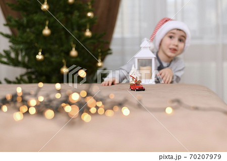 Surprised by the surprise of the child with an astonished look from a passing toy car with Christmas gifts. Surprised by the surprise of the child with an astonished look from a passing toy car with Christmas gifts. 70207979