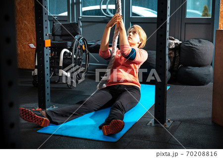 Disabled woman training in the gym of rehabilitation center Disabled woman training in the gym of rehabilitation center 70208816