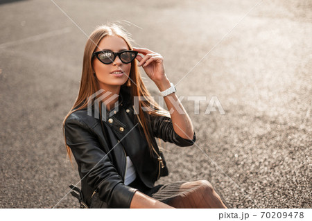 Cheerful pretty young hipster woman in a stylish Cheerful pretty young hipster woman in a stylish 70209478