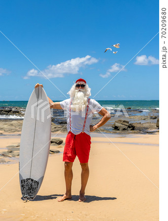 Santa Claus holds gift boxes with the ocean on backgraund 70209680