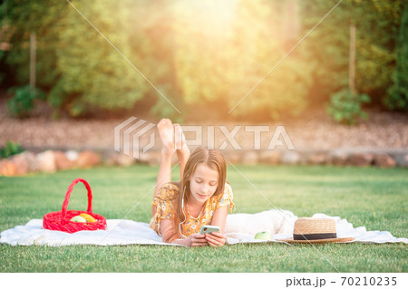Little girl outdoors in the park with computer 70210235