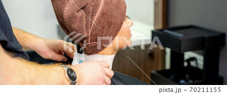Hairdresser puts on black cape to female customer 70211155