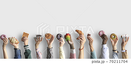 People are holding different desserts in their hands. The concept of food and sweets. 70211704