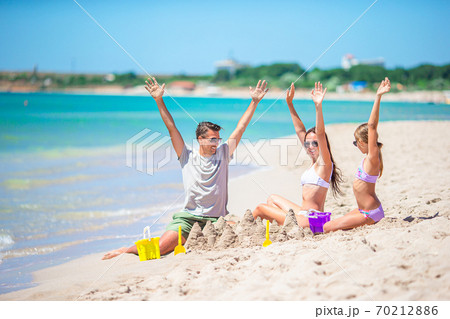 Father and kids making sand castle at tropical beach. Family playing with beach toys 70212886