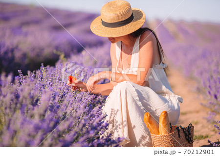 Woman in lavender flowers field at sunset in white dress and hat Woman in lavender flowers field at sunset in white dress and hat 70212901