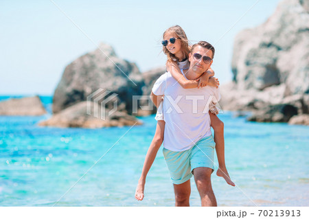 Little girl and happy dad having fun during beach vacation 70213913