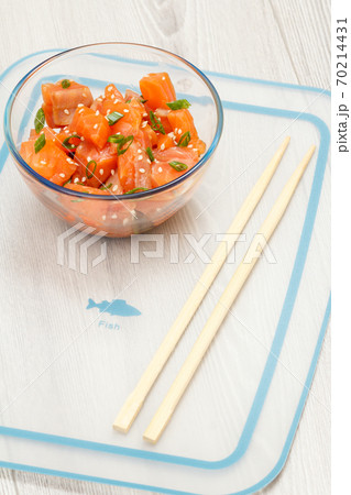 Hawaiian salmon poke with green onions and sesame seeds in glass bowl 70214431