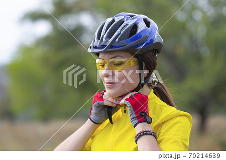 Beautiful girl cyclist in yellow wearing a helmet. Sports and recreation. 70214639