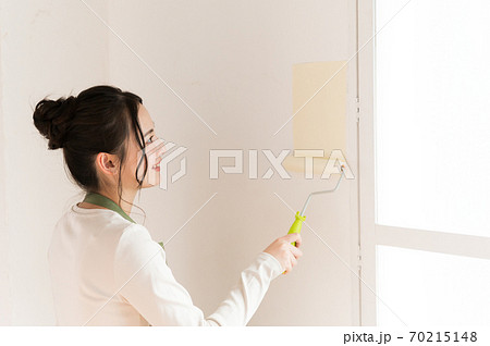 DIYで家の壁にペンキを塗る女性 70215148