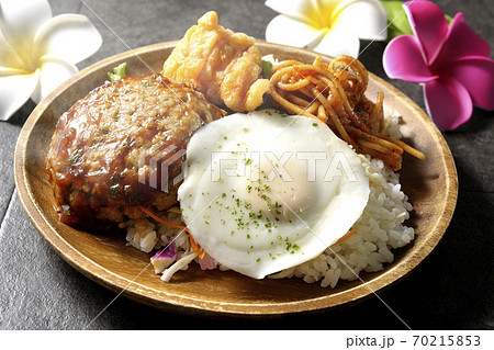 唐揚げやナポリタンも一緒に乗っている熱々のロコモコ丼とプルメリアの造花 70215853