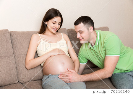 Young man talking his pregnant wife's belly. maternity concept Young man talking his pregnant wife's belly. maternity concept 70216140