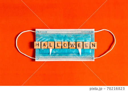 lettering Halloween on a medical protective mask on a black background with silhouettes of bats made 70216823