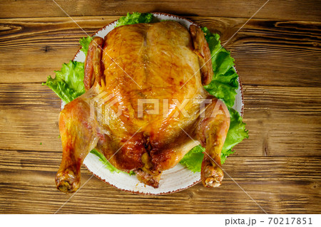 Baked whole chicken on a wooden table. Top view Baked whole chicken on a wooden table. Top view 70217851