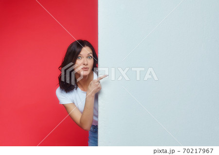 beautiful girl gestures to an empty space for the text. Presentation of your product. 70217967