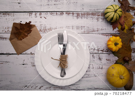 autumn composition with pumpkins and cutlery on an old table autumn composition with pumpkins and cutlery on an old table 70218477