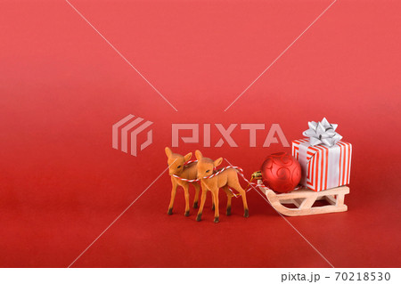 Christmas or New year background design. Reindeer with winter sleigh and gift box on red background. Christmas background with space for text. 70218530