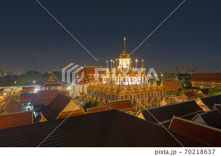 Loha Prasat Wat Ratchanatda and Golden Mountain pagoda, a buddhist temple or Wat Saket with skyscraper buildings in Bangkok Downtown, urban city, Thailand. Thai Landmark. Architecture at night. 70218637