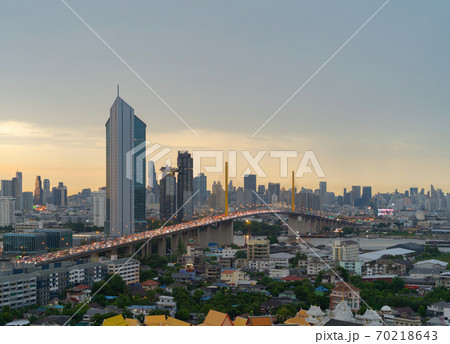 Aerial view of Rama 9 bridge and Kasikorn Building, with skyscraper high rise buildings in urban city, Downtown Bangkok skyline, Thailand at sunset. Aerial view of Rama 9 bridge and Kasikorn Building, with skyscraper high rise buildings in urban city, Downtown Bangkok skyline, Thailand at sunset. 70218643