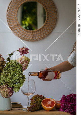 Bath tub with flower petals, grapefruit slices, bunch of grapes and woman's hand holding a bottle of wine Bath tub with flower petals, grapefruit slices, bunch of grapes and woman's hand holding a bottle of wine 70219717