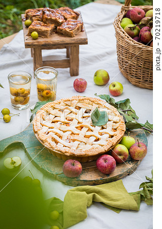 Freshly baked apple pie with stewed fruit glasses and tree branches Freshly baked apple pie with stewed fruit glasses and tree branches 70219718