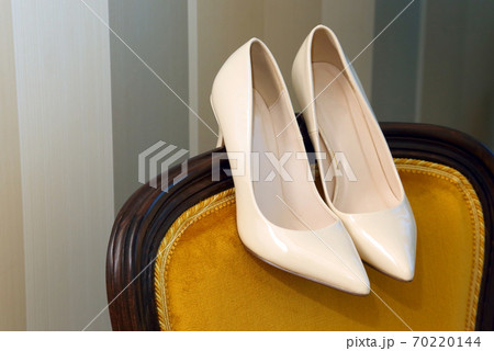 wedding shoes are on the back of the chair. wedding shoes are on the back of the chair. 70220144