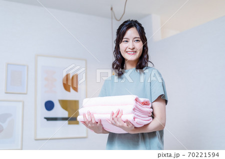 自宅で洗濯物を運ぶ若い主婦 自宅で洗濯物を運ぶ若い主婦 70221594