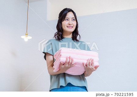 自宅で洗濯物を運ぶ若い主婦 自宅で洗濯物を運ぶ若い主婦 70221595