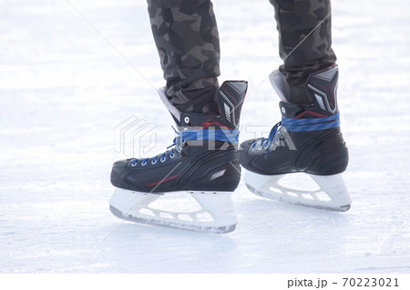 Legs of a man skating on an ice rink. Hobbies and sports. Vacations and winter activities Legs of a man skating on an ice rink. Hobbies and sports. Vacations and winter activities 70223021