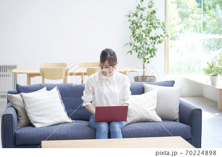 ソファーでパソコンを使う女性 70224898