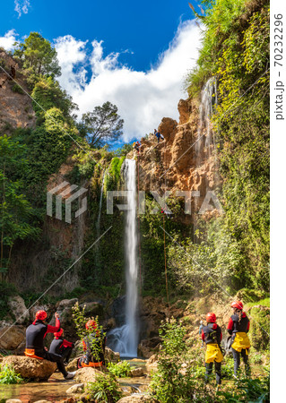 Large group enjoy waterfall descent using ropes 70232296