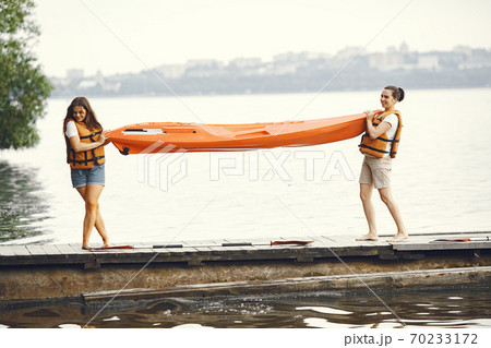 Women prepare to paddling on a lake in a kayak 70233172