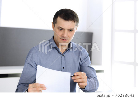 Businessman working with tablet computer in modern office. Headshot of male entrepreneur or company director at workplace. Business concept Businessman working with tablet computer in modern office. Headshot of male entrepreneur or company director at workplace. Business concept 70233643
