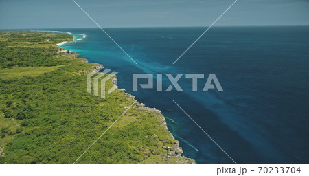 Aerial view of blue ocean bay at green tropic landscape. Greenery grass valley at cliff sea shore Aerial view of blue ocean bay at green tropic landscape. Greenery grass valley at cliff sea shore 70233704