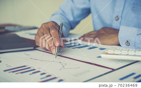 Businessmen analyze market data and calculate the cost of buying-selling products for a client's company, Professional marketing and financial accountants concept. 70236469