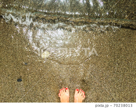 standing on wet sand on sea beach 70238013