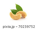 Roasted cashew nuts with green leaves isolated on white. 70239752