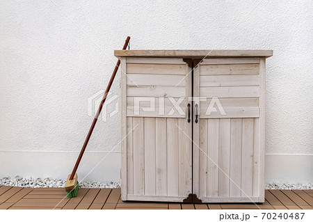 正面から見た白の収納庫と立てかけられたデッキブラシの写真素材