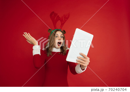 Beautiful woman like Christmas deer isolated on red background. Concept of 2021 New Year's, winter mood, holidays. Beautiful woman like Christmas deer isolated on red background. Concept of 2021 New Year's, winter mood, holidays. 70240704