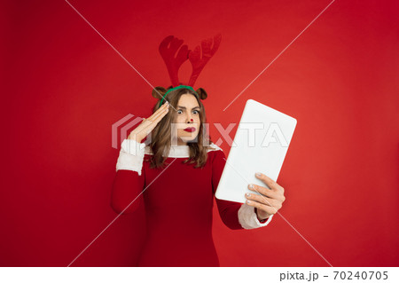Beautiful woman like Christmas deer isolated on red background. Concept of 2021 New Year's, winter mood, holidays. 70240705