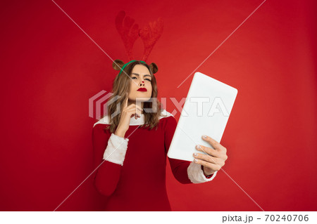 Beautiful woman like Christmas deer isolated on red background. Concept of 2021 New Year's, winter mood, holidays. Beautiful woman like Christmas deer isolated on red background. Concept of 2021 New Year's, winter mood, holidays. 70240706