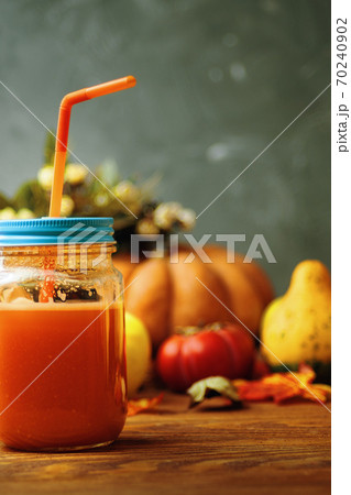 Carrot juice in bottle with pumpkins. 70240902