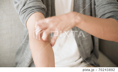 腕をかく若い男性	 70243892