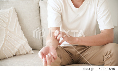 腕をかく若い男性	 70243896