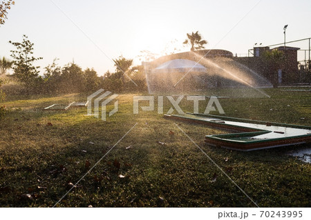Turkey Alanya, 20 October 2019: A beautiful green lawn park with trees and a golf course is sprayed 70243995