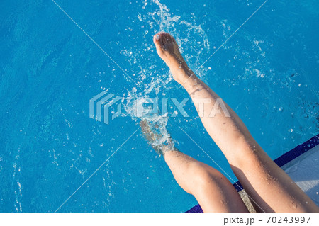 cropped young european woman kicks in the pool splashes water. Concept, carefree, summer, vacation cropped young european woman kicks in the pool splashes water. Concept, carefree, summer, vacation 70243997