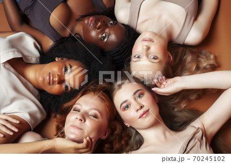young pretty asian, caucasian, afro woman posing cheerful together on brown background, lifestyle diverse nationality people concept 70245102