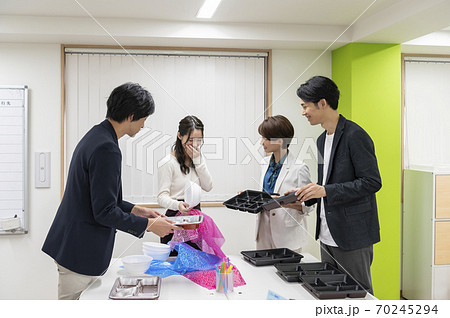 新作のお弁当の容器を決める相談をする男性・女性社員 新作のお弁当の容器を決める相談をする男性・女性社員 70245294
