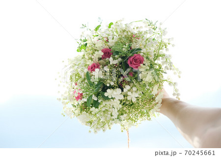 Close-up bouquet of fresh flowers rose and lily of the valley in woman hand 70245661
