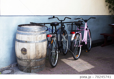 two bicycles near a barrel against the background of the coffee shop wall 70245741